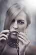 Beautiful Woman with chain in her mouth. Make up and manicure