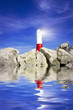 Foto: Lighthouse on rocks with lightbeam and water Lighthouse on rocks with lightbeam and water