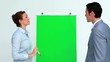 Business people talking and pointing a board