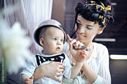 Photo: Beauty woman and baby with saucepan Beauty woman and baby with saucepan