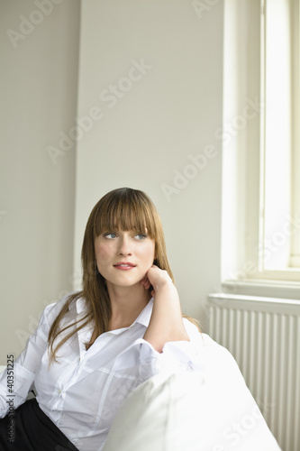 Photo: Young woman sitting on sofa Young woman sitting on sofa