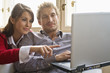 Friends using laptop, smiling