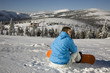 Young man sitting on snow, smiling