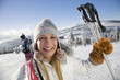 Young woman holding ski pole, portrait