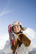 Young woman holding ski pole, smiling