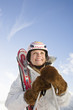 Young woman holding ski pole, smiling