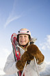 Young woman holding ski pole, smiling