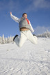 Young man jumping above snow