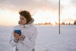 Foto: Young woman holding mug, smiling Young woman holding mug, smiling