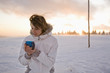 Foto: Young woman holding mug, smiling Young woman holding mug, smiling