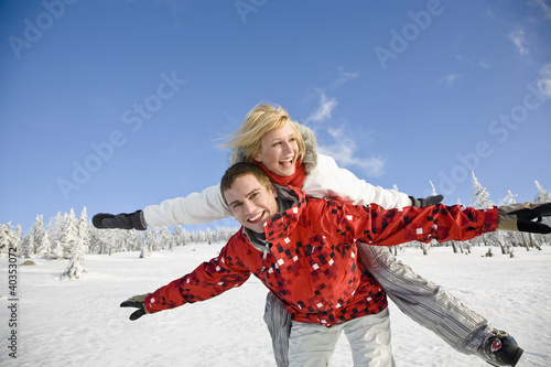 Photo: Young man giving piggyback to young woman Young man giving piggyback to young woman