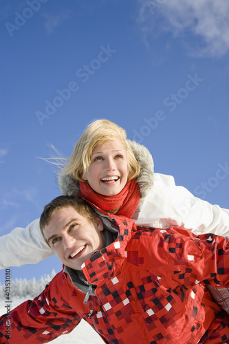 Photo: Young man giving piggyback to young woman Young man giving piggyback to young woman