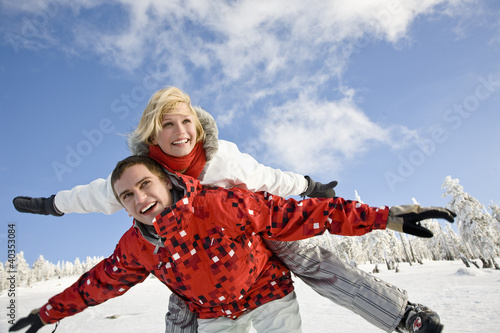 Photo: Young man giving piggyback to young woman Young man giving piggyback to young woman