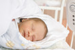Baby sleeping on bed with red spots on face, close-up