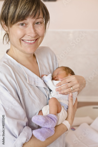 Photo: Mother carrying baby, smiling, portrait Mother carrying baby, smiling, portrait