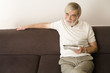 Senior man holding newspaper, smiling, portrait