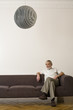 Foto: Senior man sitting on sofa with legs crossed at knee Senior man sitting on sofa with legs crossed at knee