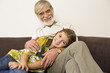 Girl lying on grandfather's leg, smiling