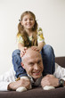 Girl sitting on man's shoulder, smiling, portrait
