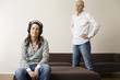 Woman wearing headphones listening to music while man standing