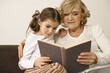 Senior woman with granddaughter reading book