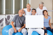 Senioren halten Schild im Fitnesscenter Senioren halten Schild im Fitnesscenter
