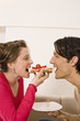 Man and woman sharing sandwich