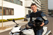 junger mit motorrad und helm