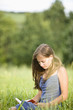 Mid adult woman reading book on field