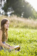 Mid adult woman holding book on field, portrait