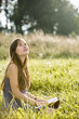 Mid adult woman holding book on field
