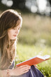 Foto: Mid adult woman reading book on field Mid adult woman reading book on field
