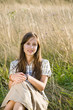 Mid adult woman sitting in field, portrait