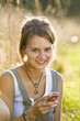 Mid adult woman holding mobile phone, smiling