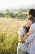 Photo: Mid adult couple embracing in field Mid adult couple embracing in field