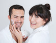 Playful young couple applying cream