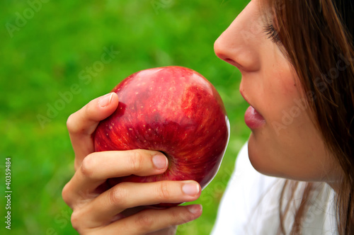 Photo: Mujer de perfil con una manzana Mujer de perfil con una manzana