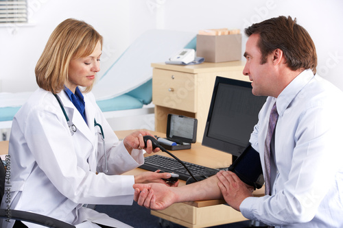 Photo: American doctor taking patient's blood pressure American doctor taking patient's blood pressure