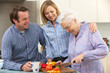 Senior woman and family preparing meal together