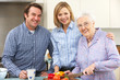 Senior woman and family preparing meal together