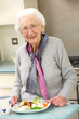 Photo: Senior woman enjoying meal in kitchen Senior woman enjoying meal in kitchen