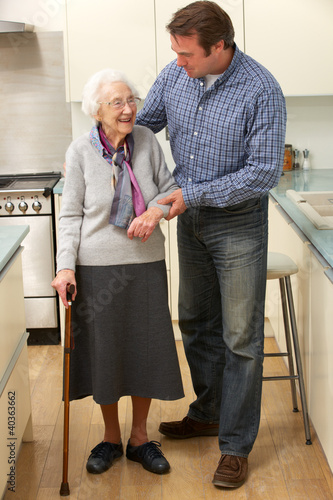 Photo: Mother and adult son in kitchen Mother and adult son in kitchen