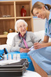 UK nurse visiting senior woman at home