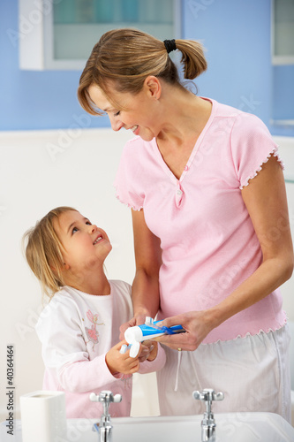 Photo: Mother and daughter cleaning teeth in bathroom Mother and daughter cleaning teeth in bathroom