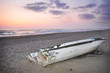Photo: Barca abbandonata sulla spiaggia al tramonto Barca abbandonata sulla spiaggia al tramonto