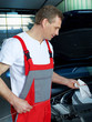 Master mechanic in a garage cleans oil dipstick