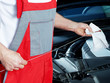 Master mechanic in a garage cleans oil dipstick