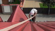 Worker on a roof walks with safety rope
