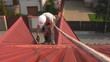 Worker on a roof walks with safety rope