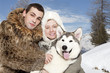 Young couple with a malamute puppy Young couple with a malamute puppy
